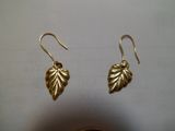 boucles d'oreilles en forme de feuille plaquées or sur fond blanc
