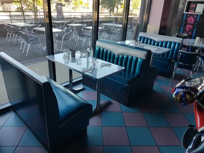 tables and chairs in a restaurant with a view of the street