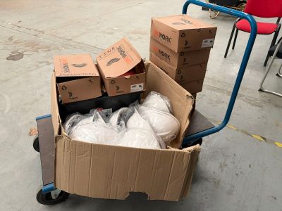 un chariot rempli de cartons et de sacs posé par terre