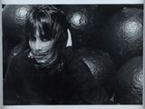a black and white photo of a woman in front of a bunch of oranges