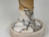 a marble vase with a wooden base on a white surface