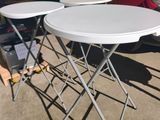 des tables et des chaises dans un parking, avec une camionnette rouge en arrière-plan