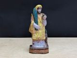 une petite statue représentant une femme tenant un bébé dans ses bras
