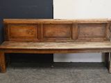 a wooden bench sitting in front of a black door