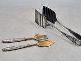 three forks and a knife on a white table