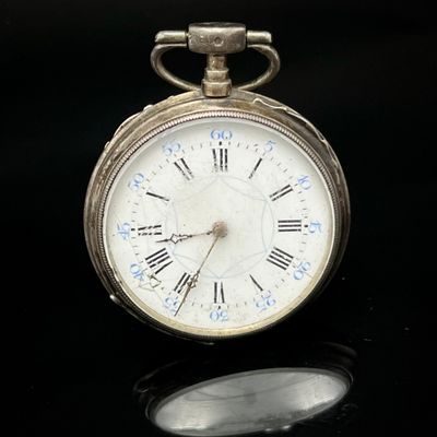 une montre de poche en argent avec des chiffres romains sur le cadran