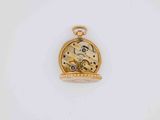 a close up of a gold pocket watch on a white surface