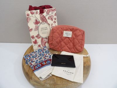 a bag, wallet, napkins, and a purse on a table