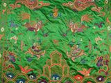 a close up of a green cloth with colorful designs on it