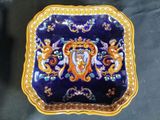 a blue and gold plate with a picture of a man on it