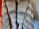 un manteau de fourrure suspendu à un portant dans une pièce