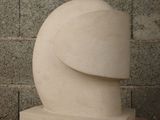 a white sculpture on a wooden table next to a brick wall