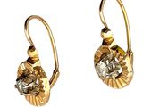 paire de boucles d'oreilles dorées ornées de cristaux transparents sur fond blanc