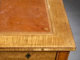 a wooden desk with a leather top and drawers