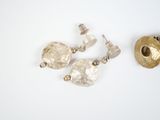 three pieces of silver and gold jewelry on a white surface