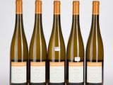quatre bouteilles de vin sont alignées sur une surface blanche