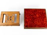 a small wooden box with a red velvet inside