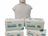 trois boîtes de masques faciaux et une tête de mannequin sur fond blanc