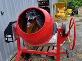 a red cement mixer sitting in front of a building
