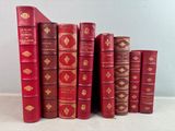 de nombreux livres rouges alignés sur une surface blanche