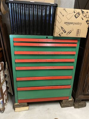 une commode verte et rouge surmontée d'une boîte