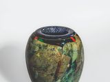 a small vase with a blue lid sitting on a white surface