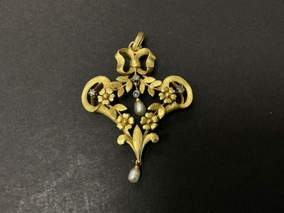 un gros plan sur une broche en or et perles