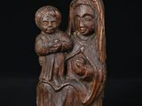 une statue en bois représentant une femme tenant un enfant sur ses genoux