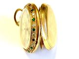 an image of a close up of a gold locke with emeralds on it