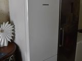 a refrigerator and a microwave on top of it in a room