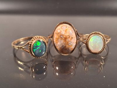 three rings with oplite and oplite stones on a table
