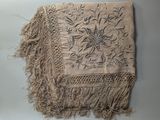 an image of a piece of cloth with fringes on a table
