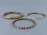 trois bracelets de couleurs différentes posés sur une surface grise
