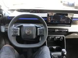 a man sitting in the driver ' s seat of a car