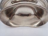 silver plated bowl with a handle on a white surface