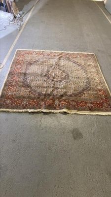 un tapis posé au sol au milieu d'une pièce, avec de nombreux meubles en arrière-plan