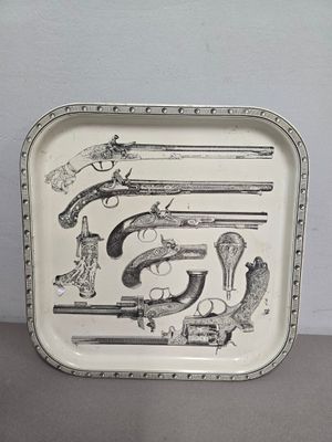 un plateau sur lequel sont posées plusieurs armes à feu