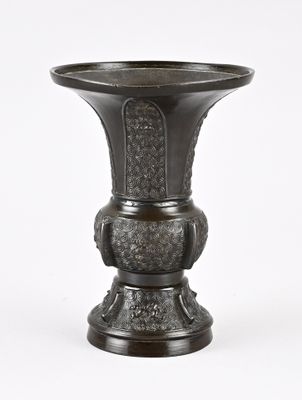 un vase noir posé sur une surface blanche