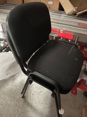 une chaise noire posée au milieu d'une pile de cartons