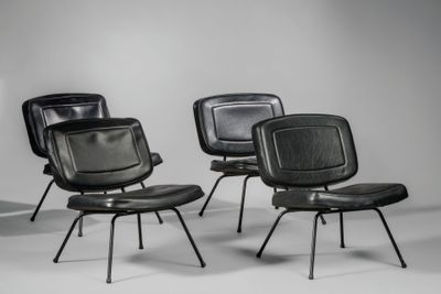 trois fauteuils en cuir noir empilés les uns sur les autres dans une pièce