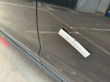 a sticker on the door of a car that is parked in a parking lot