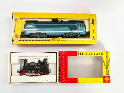 deux boîtes contenant un petit train, posées sur une surface blanche