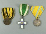 three medals and a medal on a gray surface
