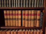 de nombreux livres anciens sur une étagère en bois dans une bibliothèque