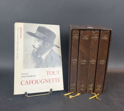 three books on a table next to a book case with a hat on it