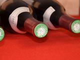 several bottles of wine are lined up on a red table