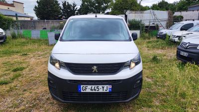 une camionnette blanche garée sur un parking avec d'autres voitures