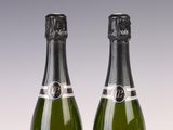 two bottles of champagne sitting next to each other on top of a table