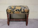 un petit banc en bois avec une assise rembourrée à motifs floraux