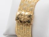 yellow gold plated bracelet on a white pillow on a white surface